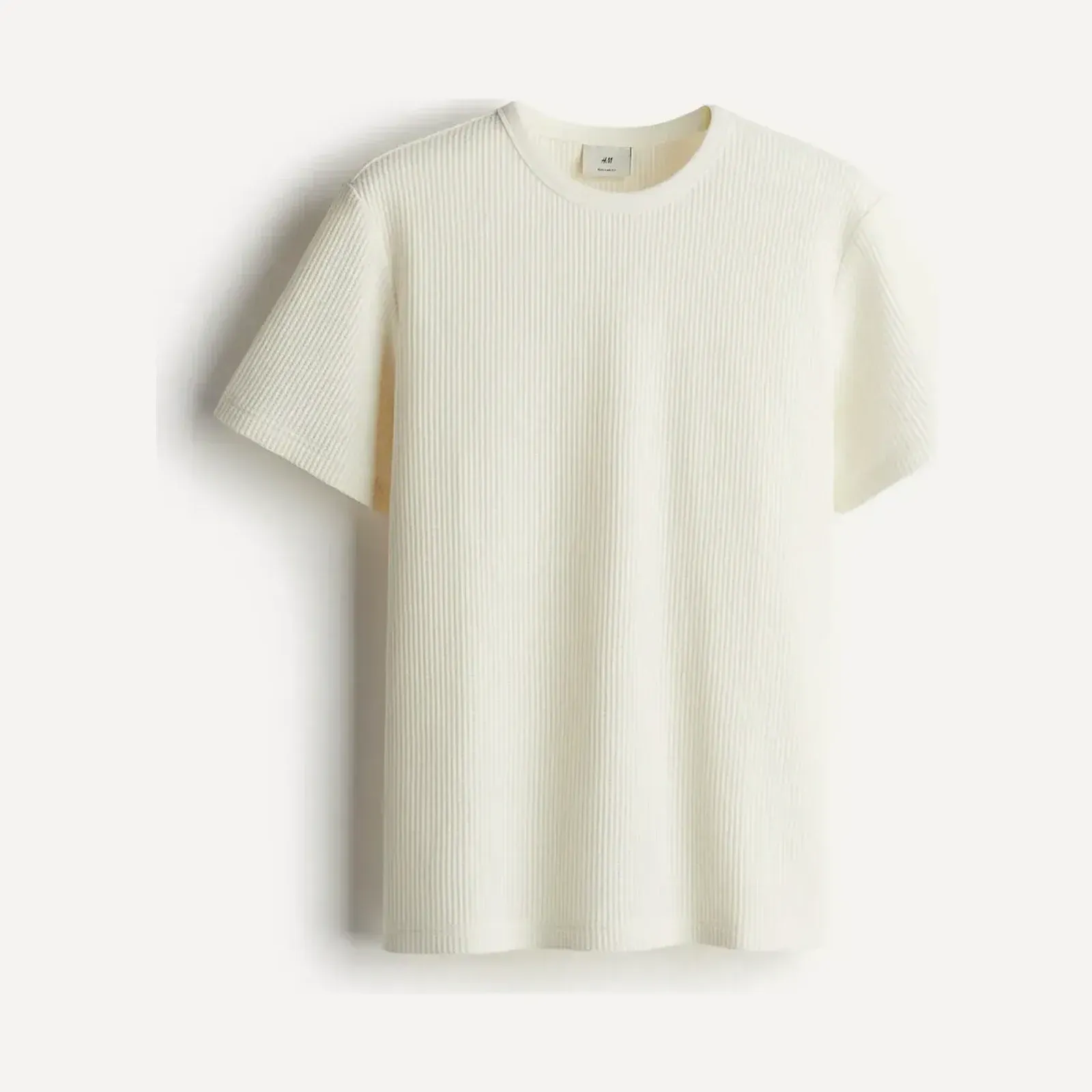 Kremowy t-shirt H&M z krótkim rękawem o fakturze waflowej, z okrągłym, prążkowanym dekoltem, ujęcie produktowe.