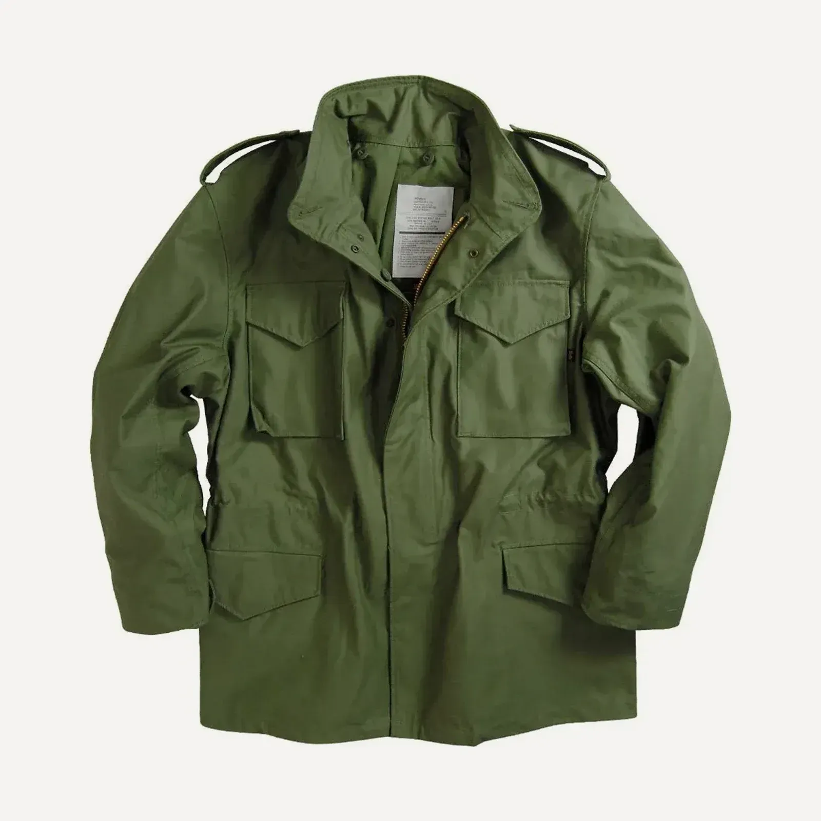 Oliwkowa wojskowa kurtka field jacket typu M-65 na jasnym tle — stójka z krytym kapturem, kryty zamek, cztery naszywane kieszenie z patkami i pagony na ramionach.