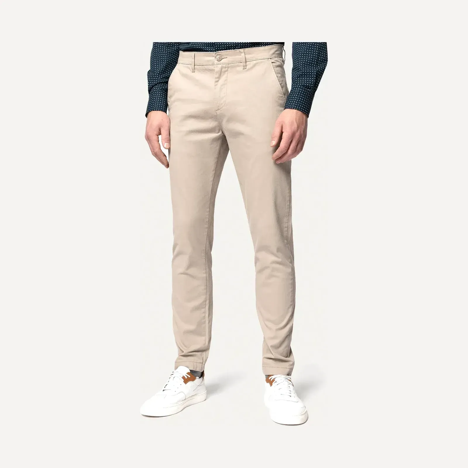 Beżowe męskie chinosy o dopasowanym kroju (slim fit) Próchnik, prezentowane na modelu od pasa w dół, ujęcie produktowe.